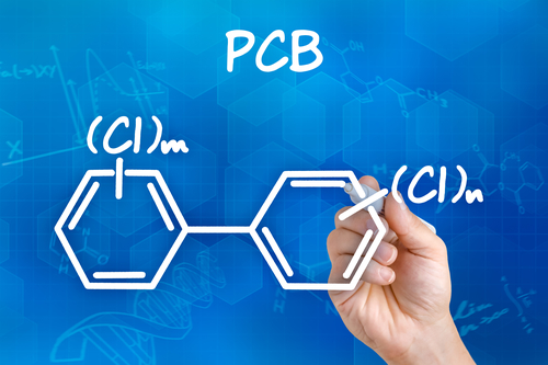 Hand with pen drawing the chemical formula of PCB